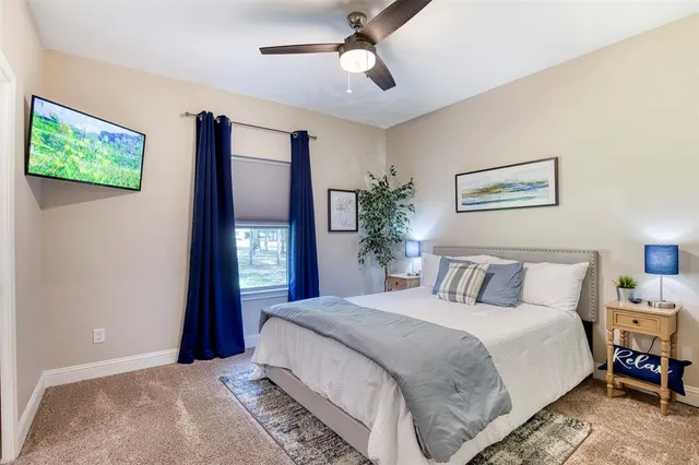 a bedroom with a large bed and a chandelier