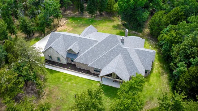 an aerial view of a house with a yard and swimming pool
