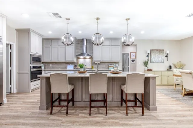 a kitchen with a dining table chairs and wooden floor
