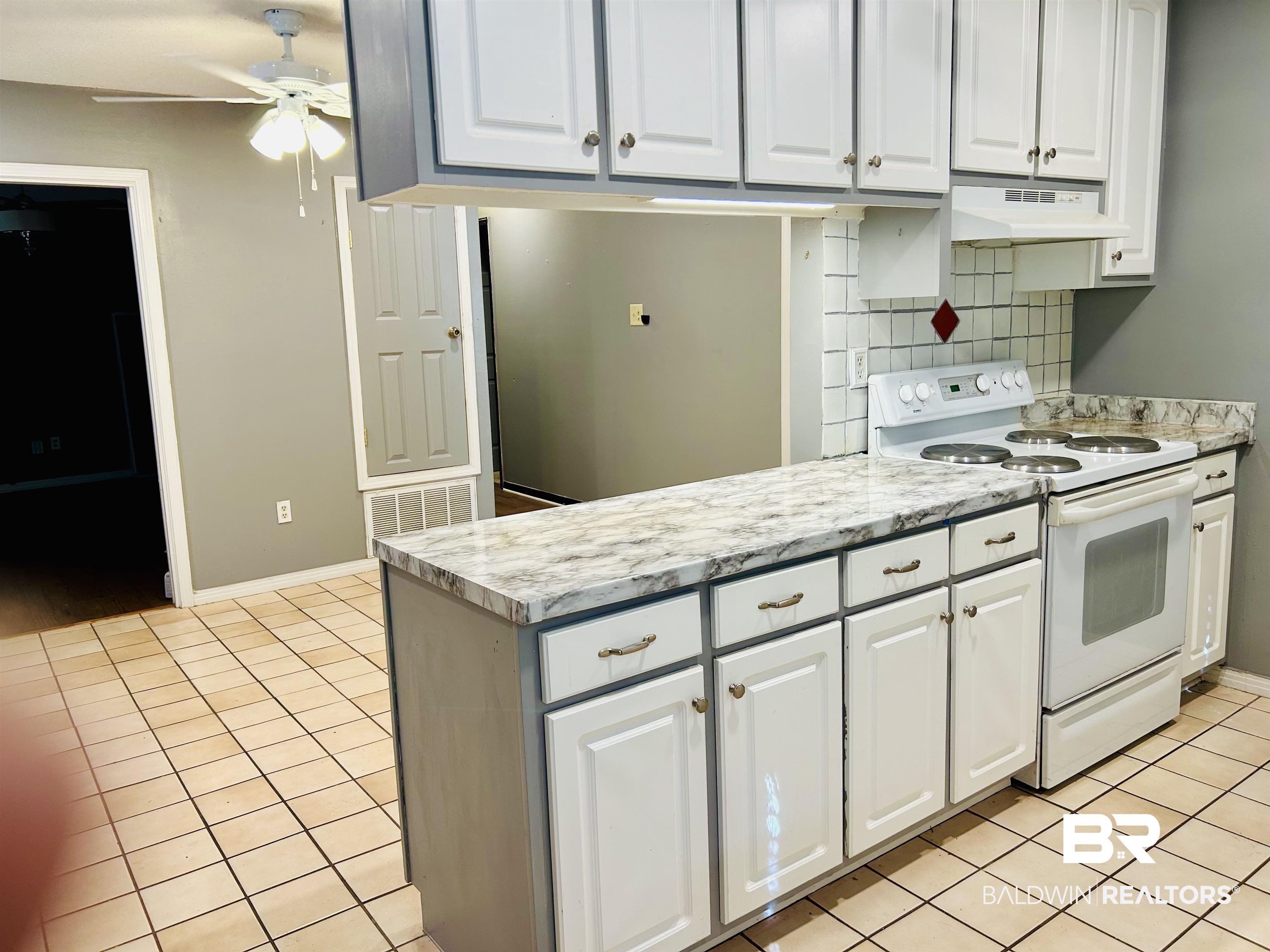 5925 Dixie Lane Mobile, AL 36693 - Photo 17 of 19 Kitchen featuring white cabinetry, light tile patterned flooring, and white electric range oven