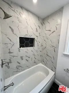 a bathroom with a bathtub and shower