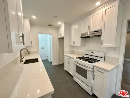 a kitchen with stainless steel appliances granite countertop a stove a sink and a refrigerator