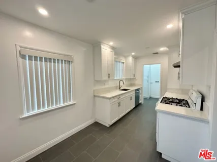 a kitchen with stainless steel appliances a stove a sink and a refrigerator