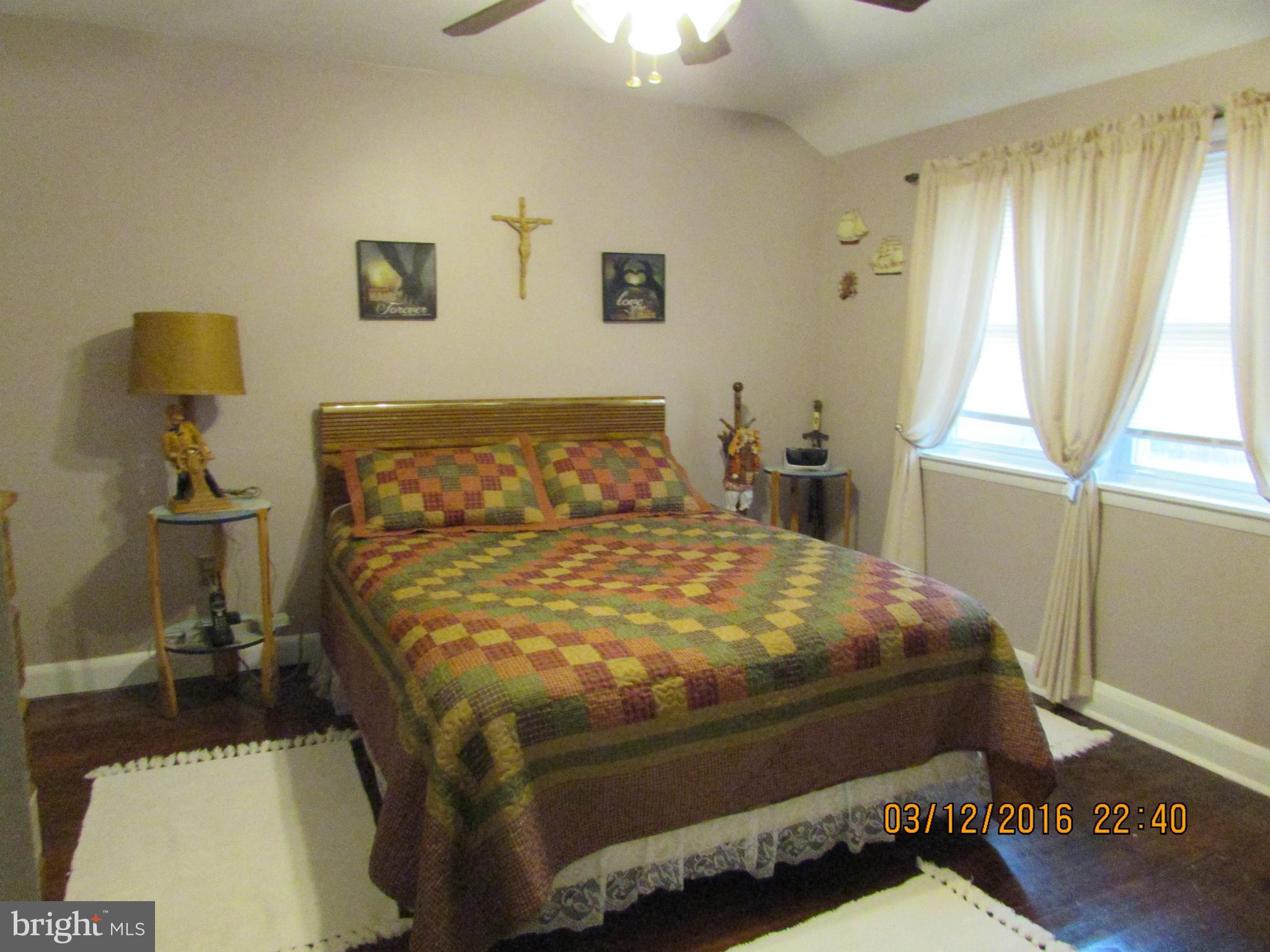 1925 Quentin Road Baltimore, MD 21222 - Photo 13 of 28 a bed sitting in a bedroom next to a window