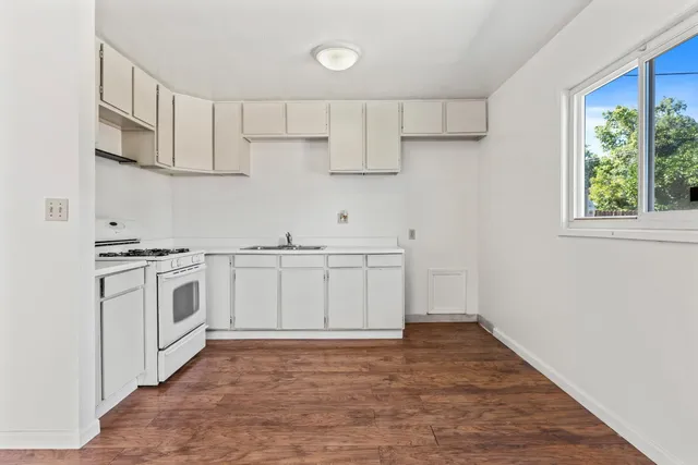 a kitchen with white cabinets and white appliances