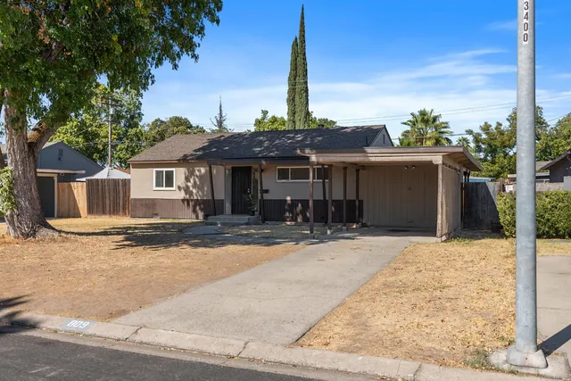 a front view of a house with a garden and yard