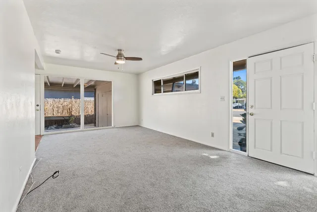 a view of a livingroom with an empty space and a ceiling fan