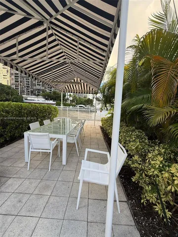 a view of a patio with a table and chairs and potted plants