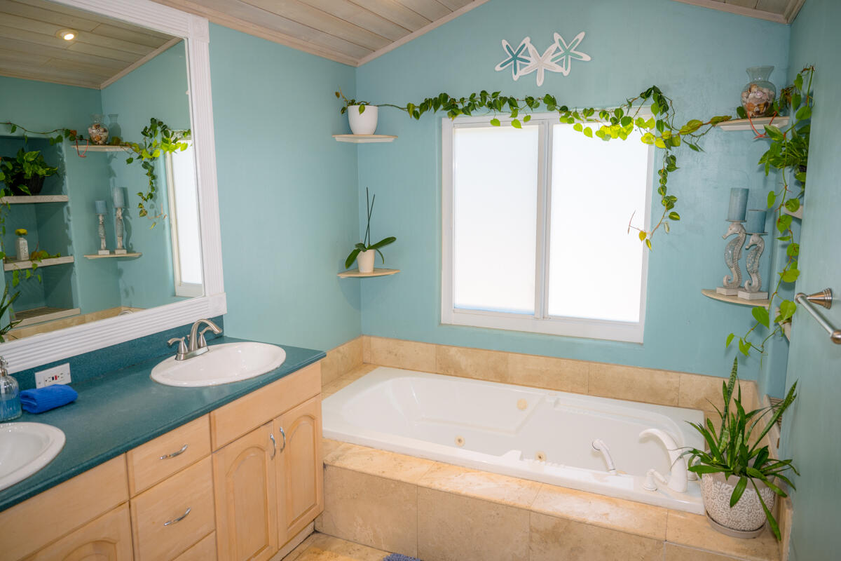 464 Lime Drive Key Largo, FL 33037 - Photo 25 of 96 a bathroom with a granite countertop sink a bathtub and a mirror