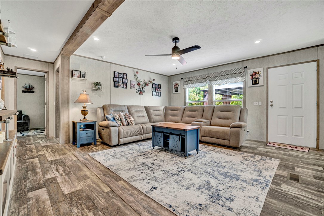 2655 State Rd S-4-108 Anderson, SC 29624 - Photo 11 of 37 Rich wood-textured flooring and a prominent timber support beam anchor this open living area.