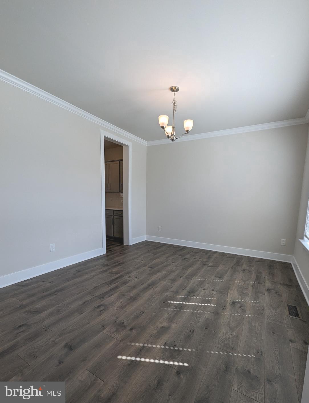 14972 Walter Robinson Lane Haymarket, VA 20169 - Photo 7 of 30 a view of an empty room with wooden floor and chandelier