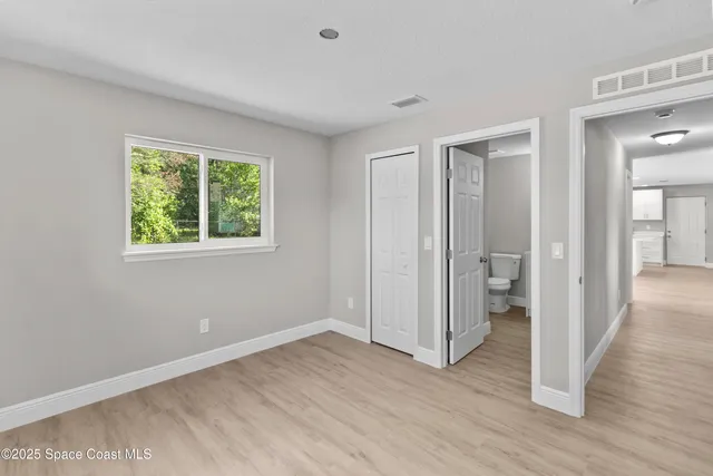 a view of a room with wooden floor closet and windows