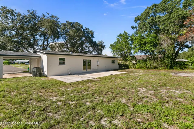 a view of a house with yard and a tree