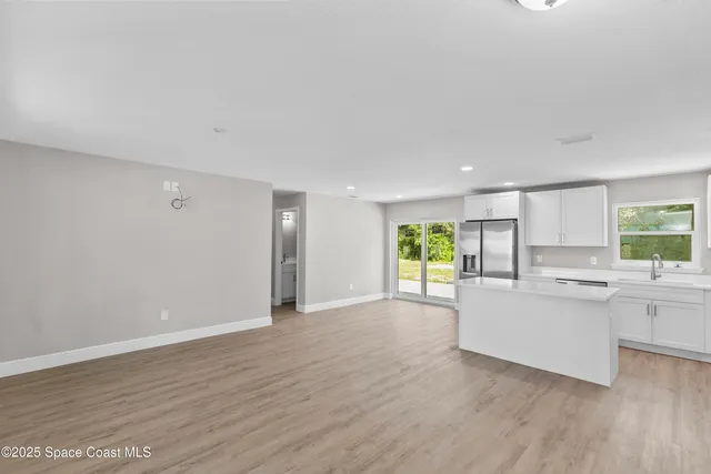 a view of a kitchen with wooden floor and a window