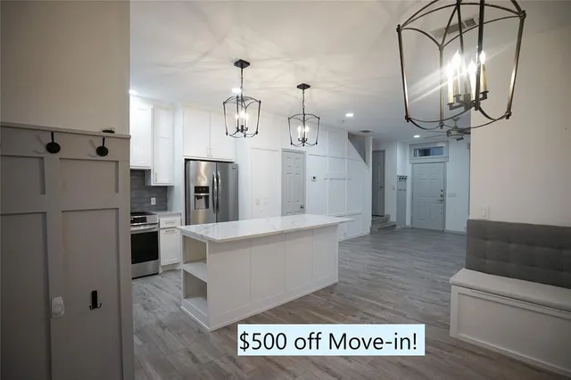 a kitchen with stainless steel appliances granite countertop a refrigerator a oven a stove and a sink