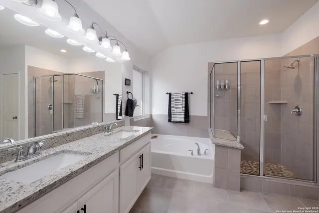 a bathroom with a granite countertop sink mirror and a bath tub
