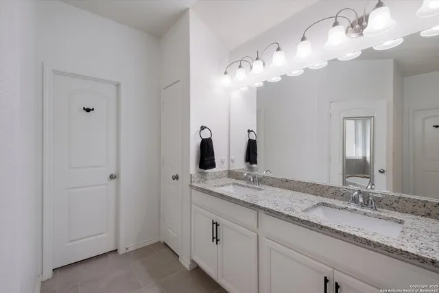 a bathroom with a granite countertop sink and a mirror