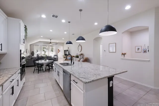a kitchen with granite countertop a table and chairs in it