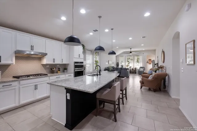 a kitchen with stainless steel appliances granite countertop a sink a stove a refrigerator and a oven