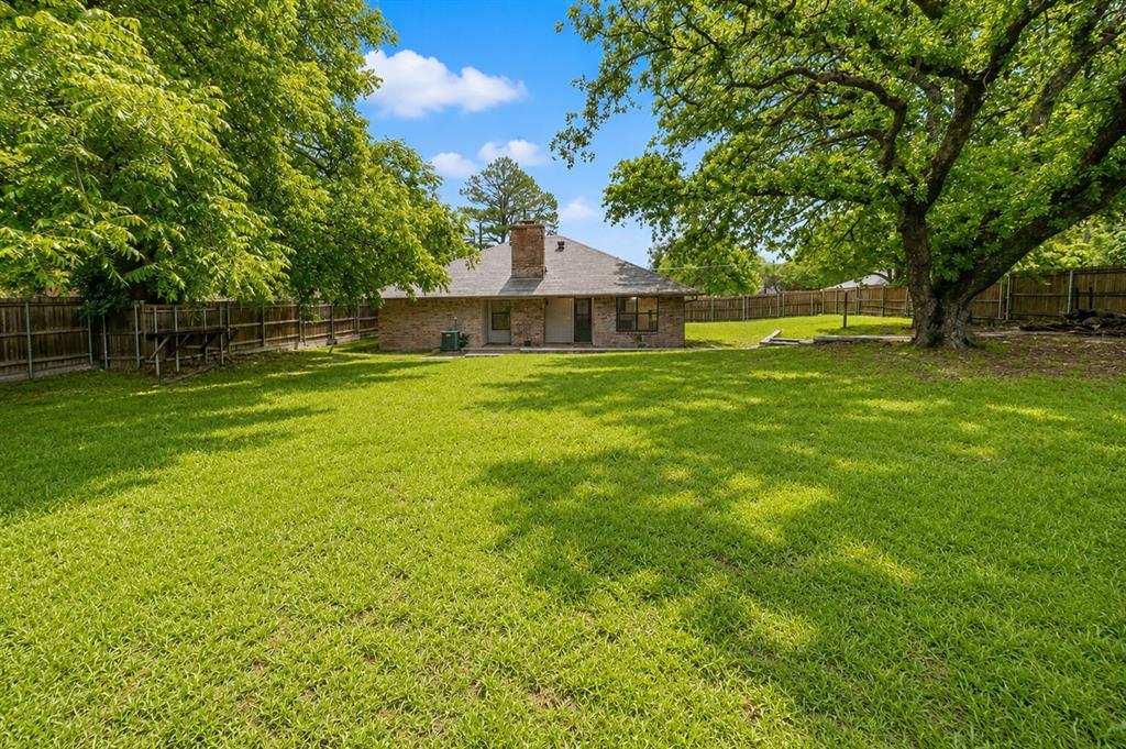 1001 Rosebud Drive Azle, TX 76020 - Photo 32 of 36 Expansive rear yard featuring a large green lawn and mature shade trees