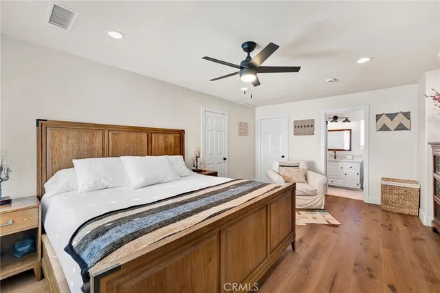 a bedroom with a bed a flat screen tv and windows