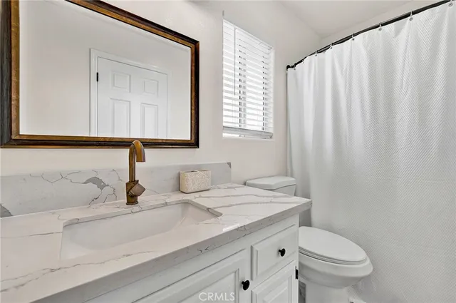 a bathroom with a sink a mirror a vanity and a bathtub