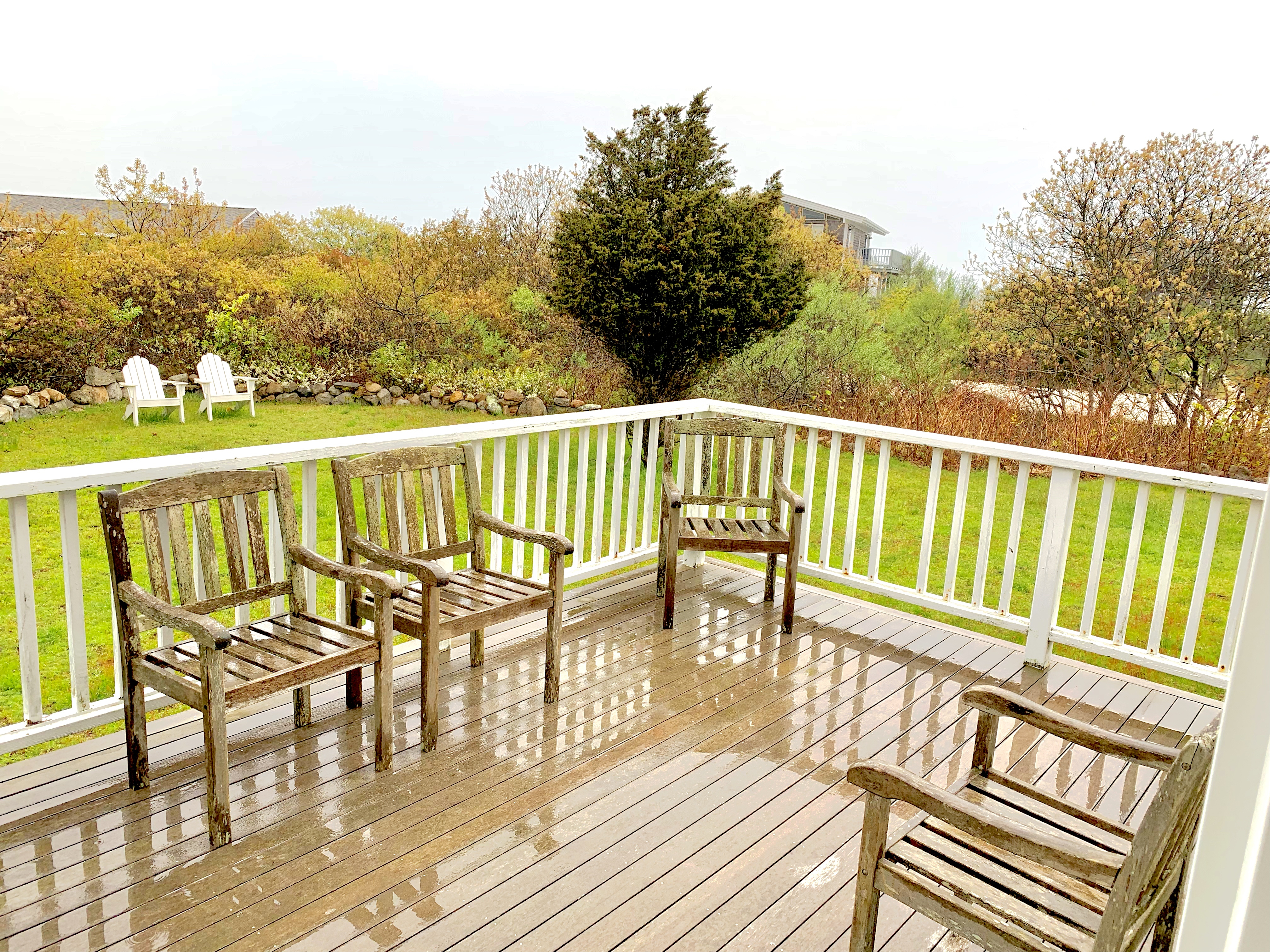 650 Lighthouse Road Aquinnah, MA 02535 - Photo 29 of 57 Deck and grassy yard lined by stonewalls with a view of the sound.