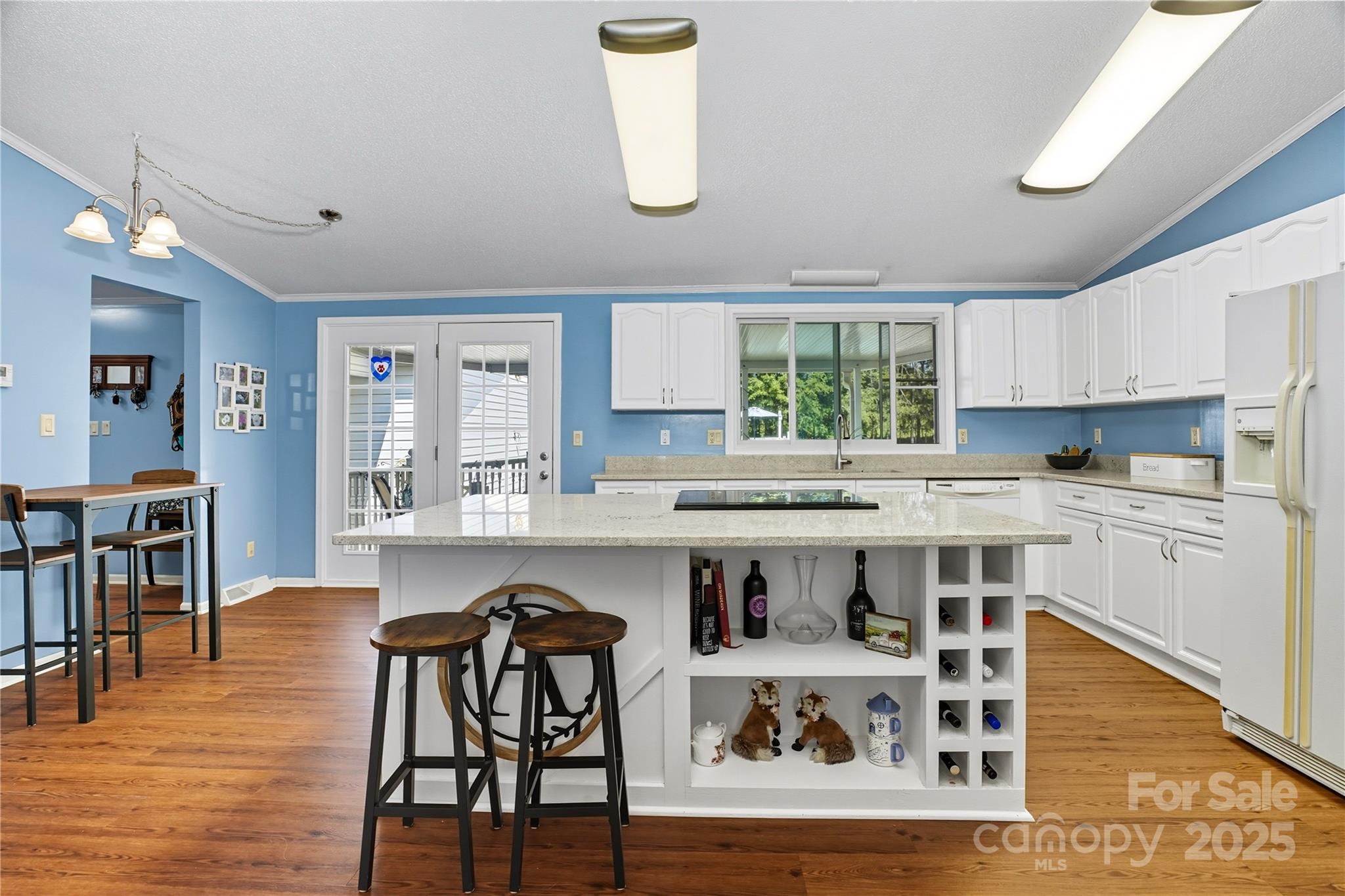 1660 Lentz Road China Grove, NC 28023 - Photo 16 of 44 a kitchen with stainless steel appliances granite countertop a stove top oven a sink a dining table and chairs with wooden floor