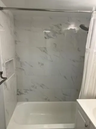a bathroom with a shower and a bath tub