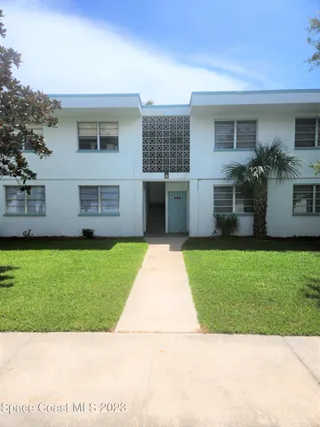 a front view of a house with a garden and yard