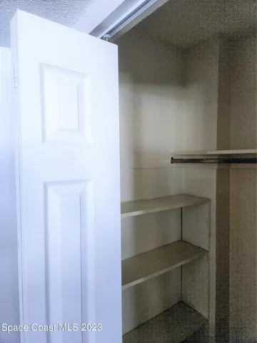 a view of walk in closet with empty racks