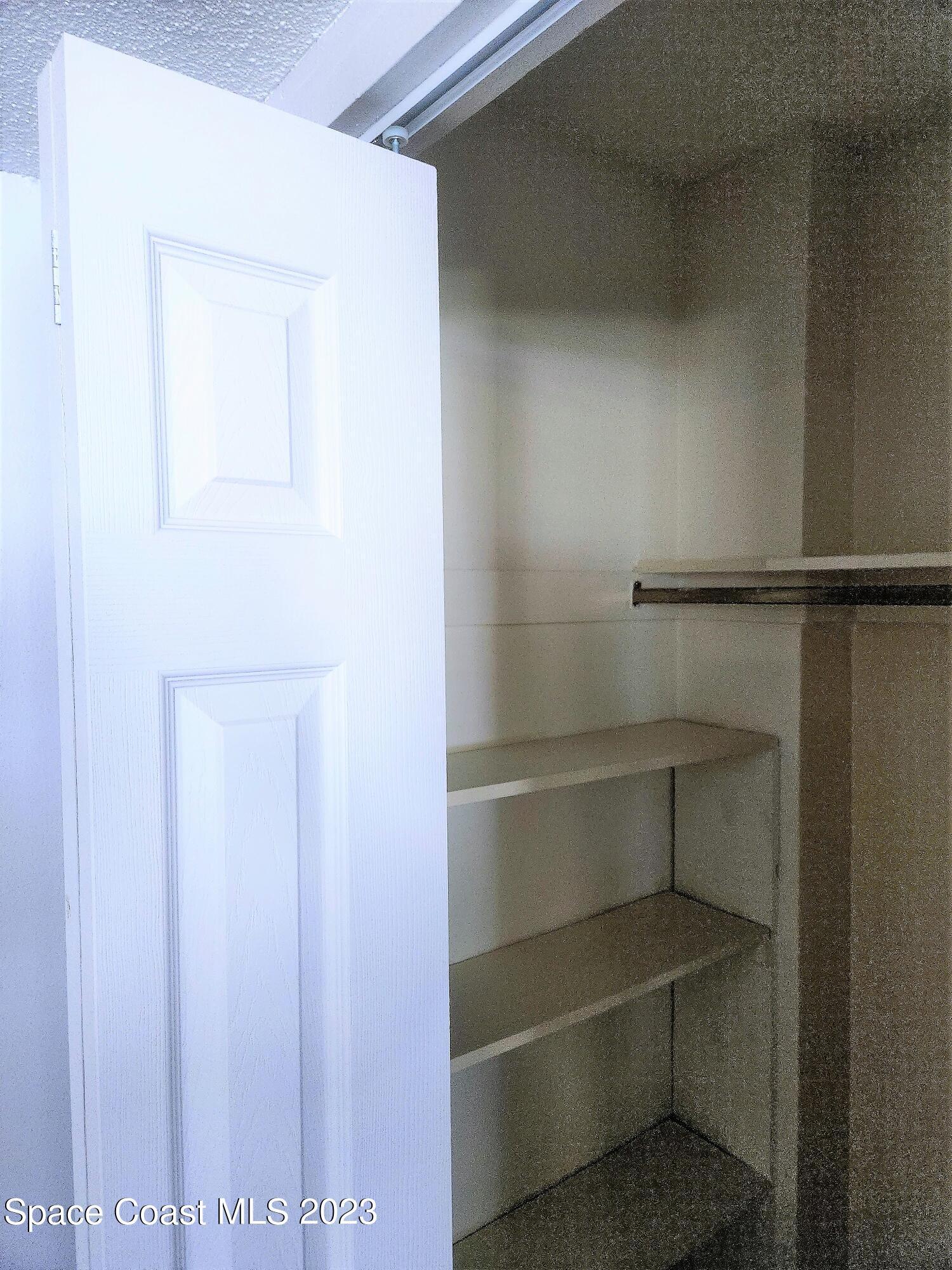 8401 North Atlantic Avenue, Unit K9 Cape Canaveral, FL 32920 - Photo 11 of 14 a view of walk in closet with empty racks