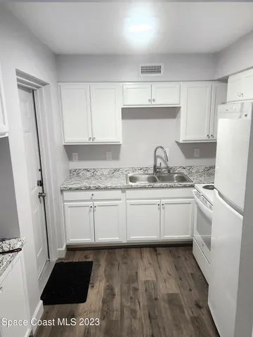 a kitchen with a sink a stove a refrigerator and cabinets