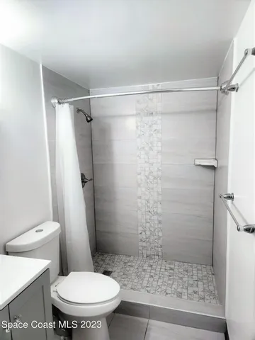 a white toilet sitting next to a shower