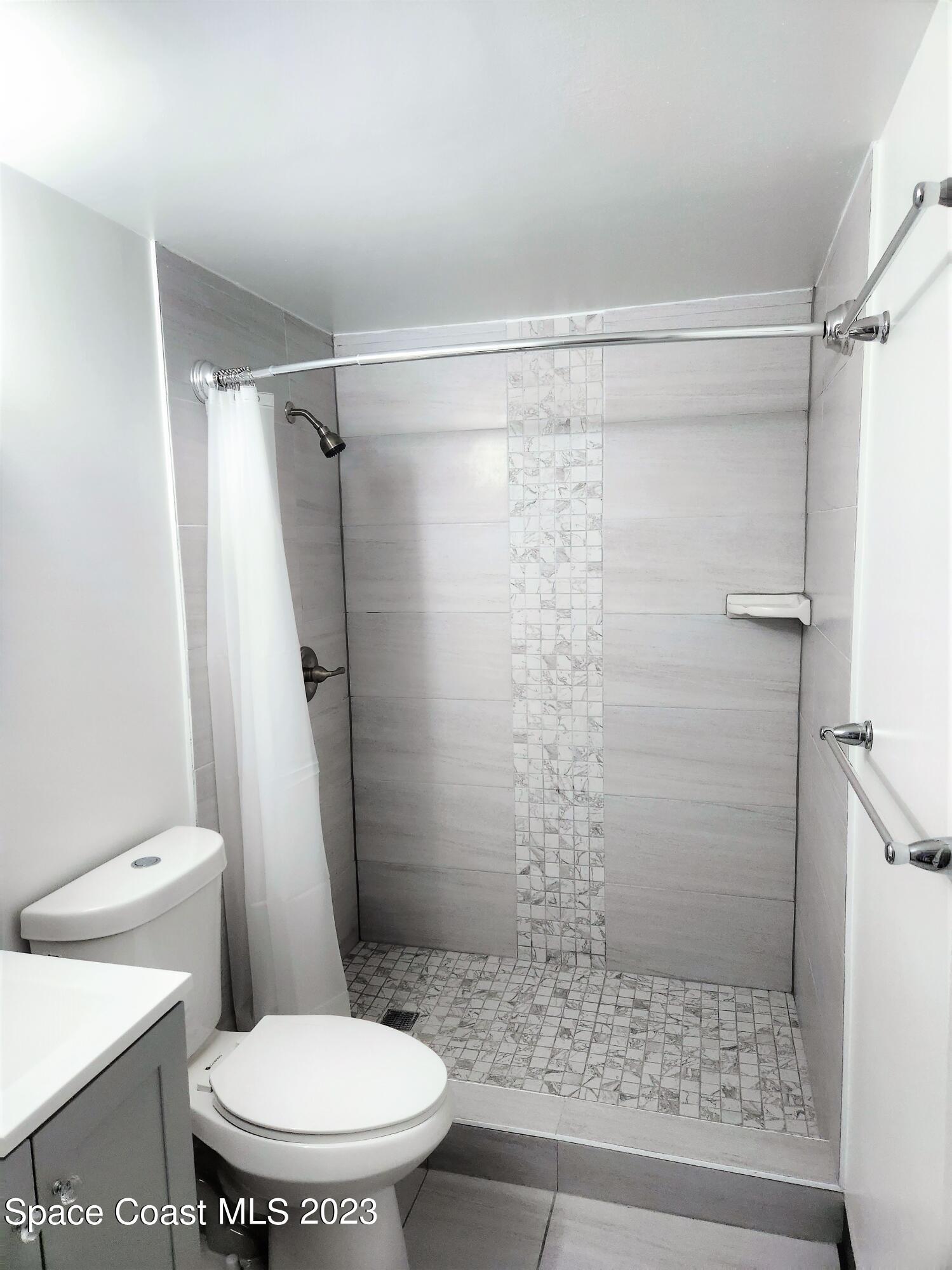 8401 North Atlantic Avenue, Unit K9 Cape Canaveral, FL 32920 - Photo 6 of 14 a white toilet sitting next to a shower