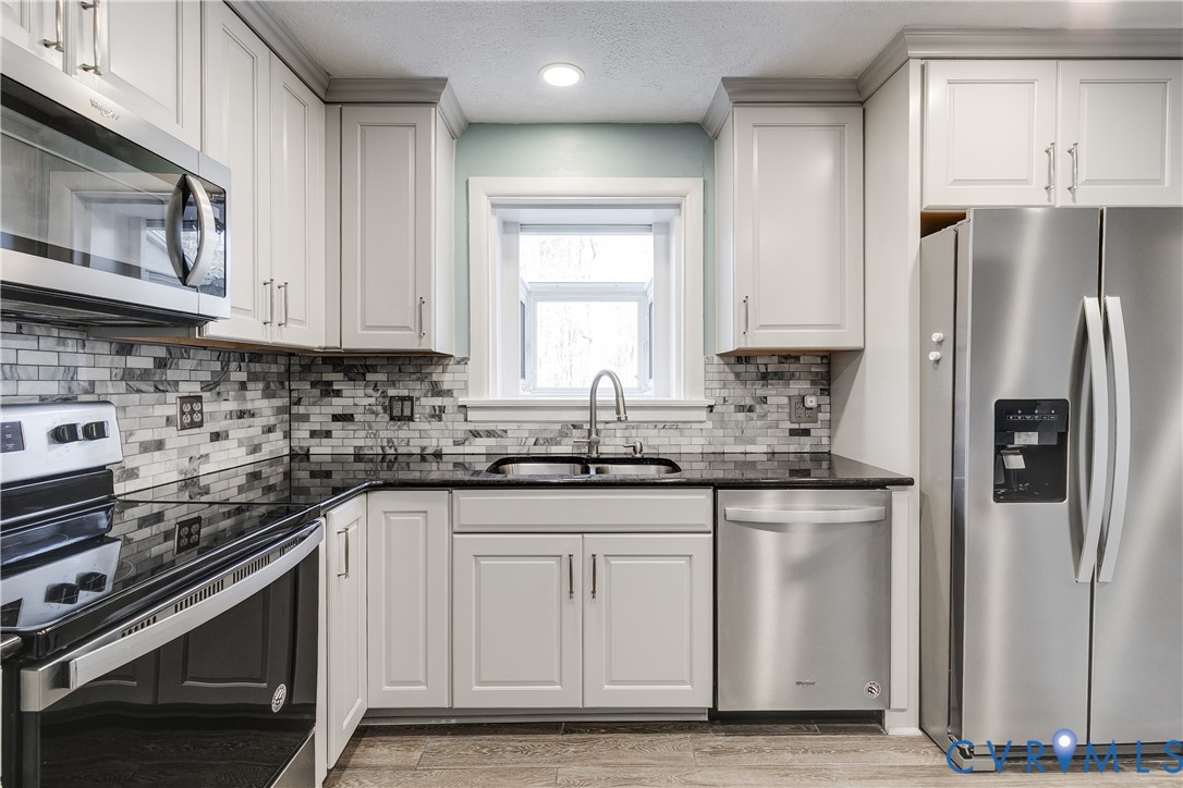 1180 Berryhill Road Henrico, VA 23231 - Photo 7 of 23 a kitchen with granite countertop a refrigerator stove and sink