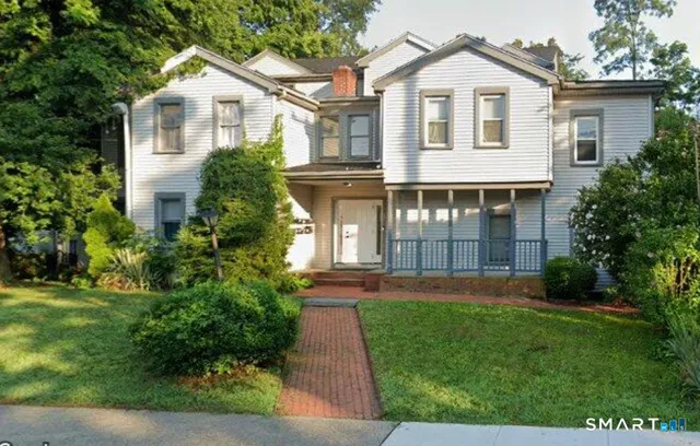 a front view of a house with a garden and yard