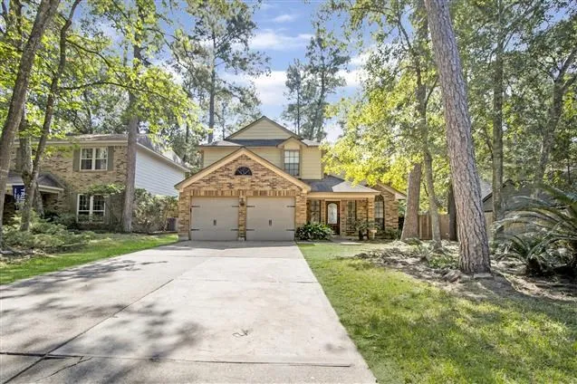 a front view of a house with a yard and trees