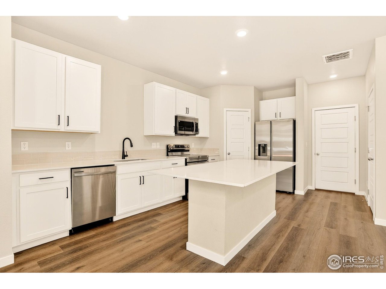 307 Penguin Street Johnstown, CO 80534 - Photo 13 of 34 Open kitchen with large island, quartz counters and appliances that stay!