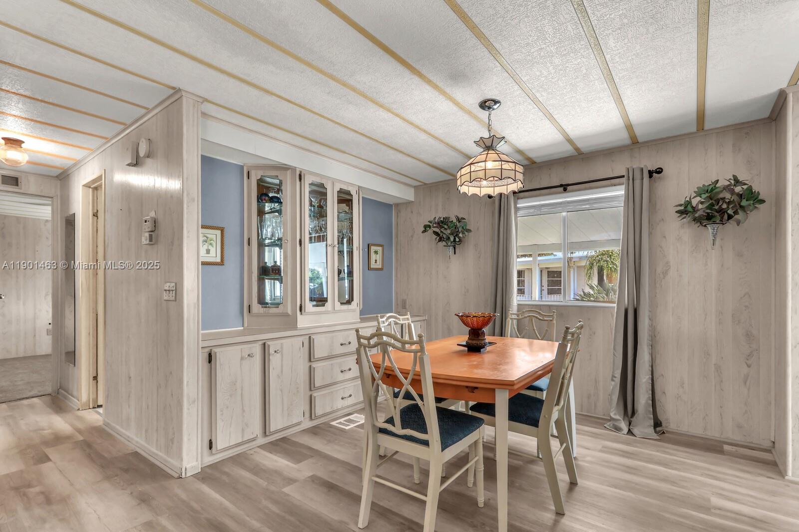 8191 Southeast Homestead Avenue, Unit 8191 Hobe Sound, FL 33455 - Photo 11 of 38 a view of a dining room with furniture window and wooden floor