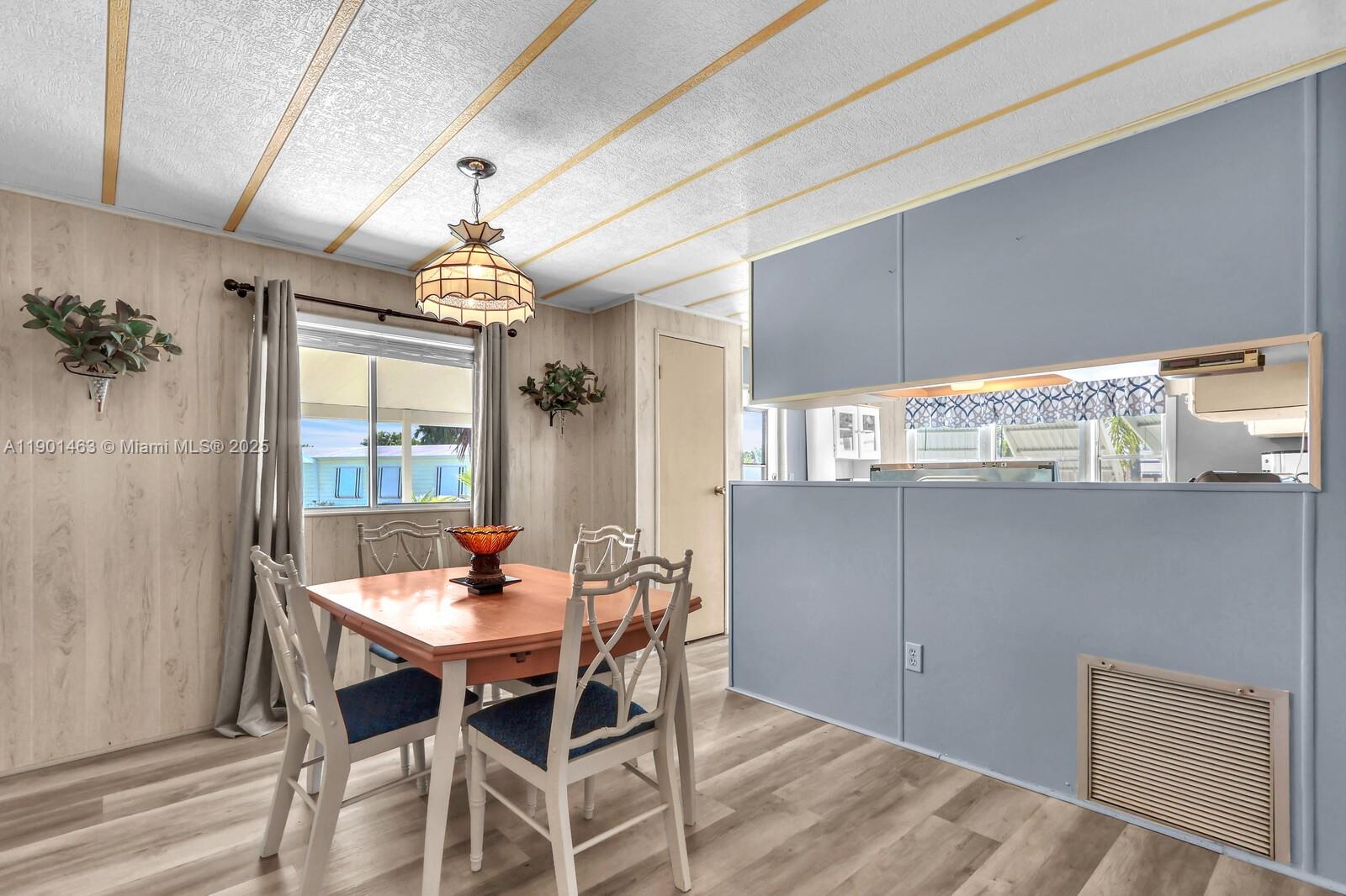 8191 Southeast Homestead Avenue, Unit 8191 Hobe Sound, FL 33455 - Photo 12 of 38 a dining room with furniture window and wooden floor