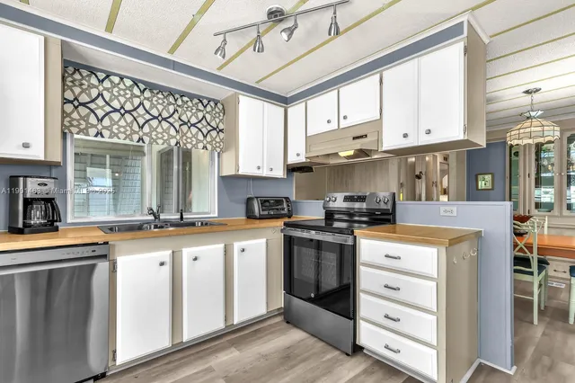 a kitchen with stainless steel appliances granite countertop a stove and cabinets
