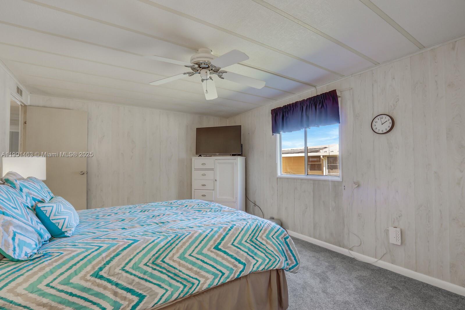 8191 Southeast Homestead Avenue, Unit 8191 Hobe Sound, FL 33455 - Photo 22 of 38 a bedroom with a bed dresser and a window