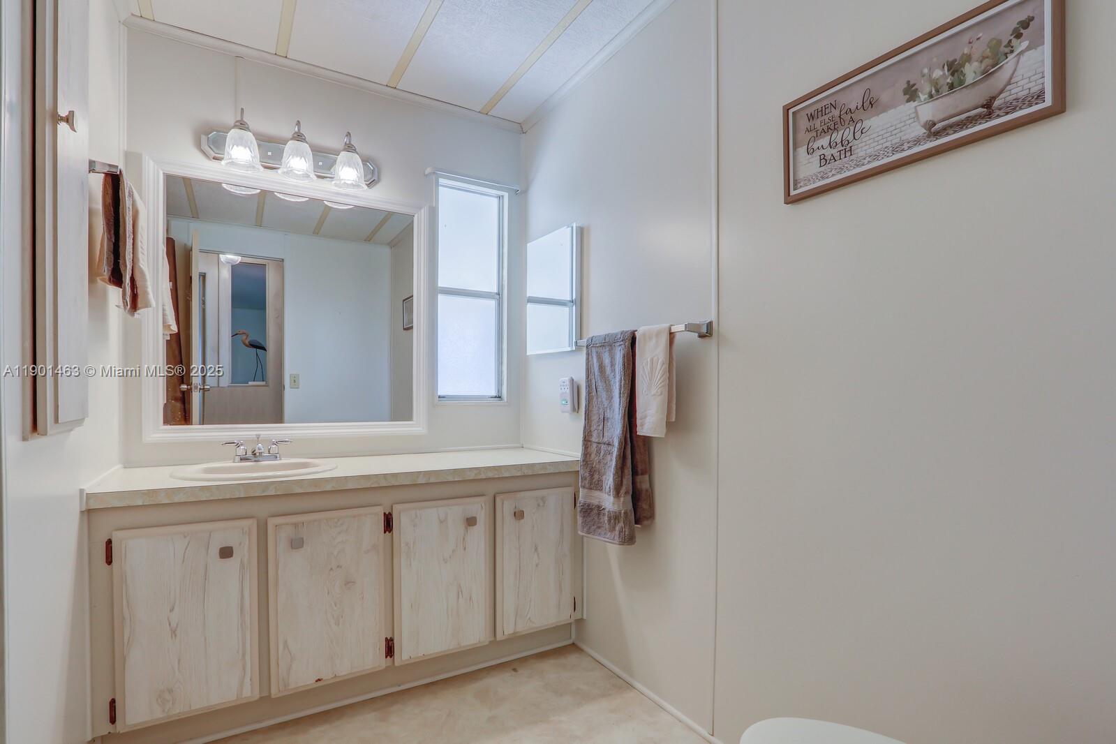 8191 Southeast Homestead Avenue, Unit 8191 Hobe Sound, FL 33455 - Photo 28 of 38 a bathroom with a double vanity sink and a mirror