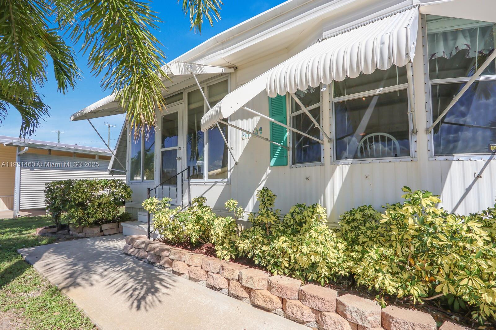 8191 Southeast Homestead Avenue, Unit 8191 Hobe Sound, FL 33455 - Photo 3 of 38 a view of a house with a flower garden