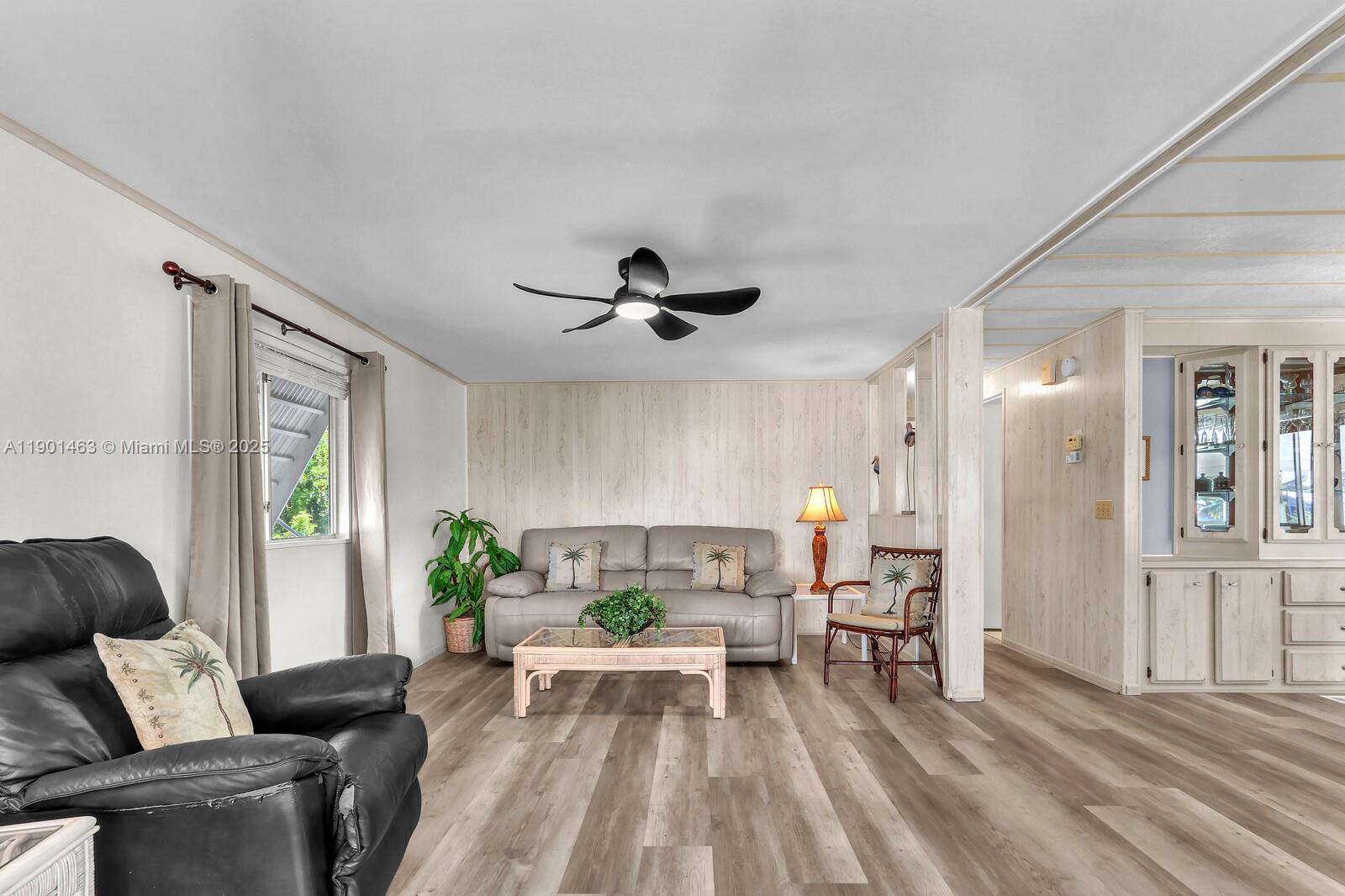 8191 Southeast Homestead Avenue, Unit 8191 Hobe Sound, FL 33455 - Photo 6 of 38 a living room with furniture and a chandelier