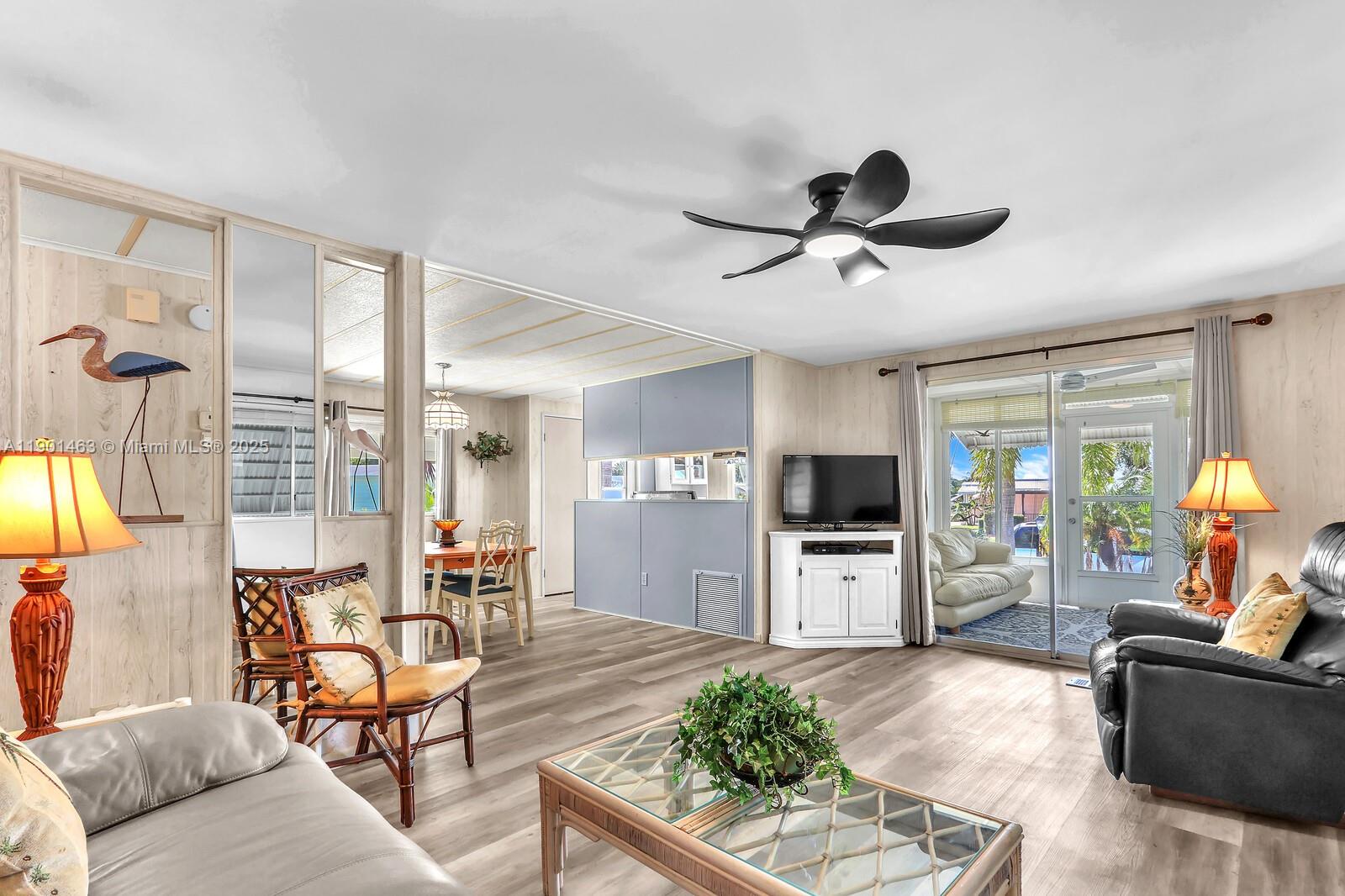 8191 Southeast Homestead Avenue, Unit 8191 Hobe Sound, FL 33455 - Photo 8 of 38 a living room with furniture and a flat screen tv