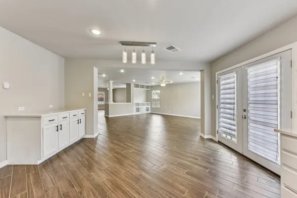 a view of a kitchen with wooden floor and a window