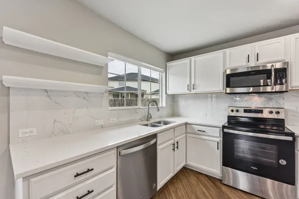 a kitchen with a sink stove and microwave