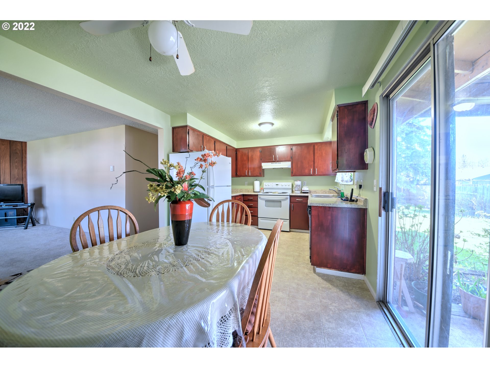 212 72nd Street Springfield, OR 97478 - Photo 6 of 21 a kitchen with stainless steel appliances kitchen island granite countertop a table chairs in it and wooden floor